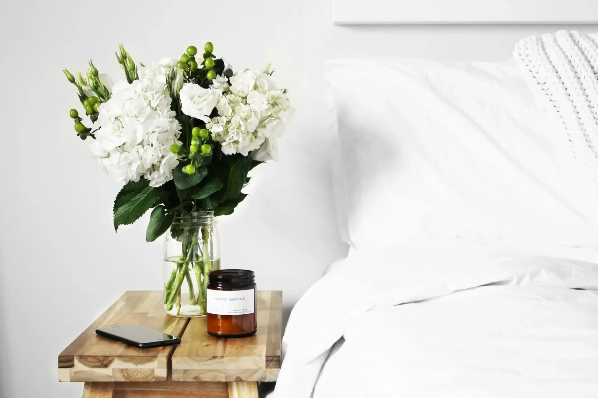 bed with vase of flowers